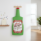 Green beer bottle fancy dress costume displayed on coat hook in bright airy room with natural window light and party props