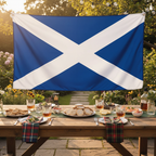 Scotland flag used as a backdrop at a Scottish-themed garden party with whisky and shortbread on a rustic wooden table