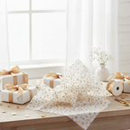 Gold star tissue paper on a celebration gift wrapping table with presents and ribbon, natural window light, lifestyle setting