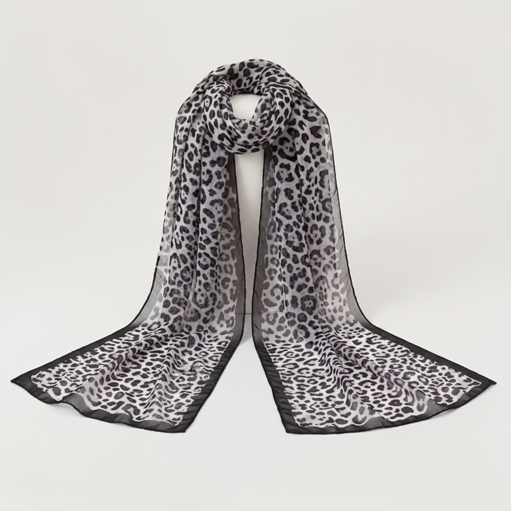 Women's long chiffon leopard animal print scarf in black and grey on white background showing sheer fabric and pattern detail