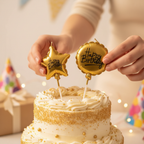 Hands placing gold metallic balloon birthday candles into celebration cake