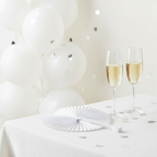 White heart paper fan at a hen party table setting with champagne glasses and white balloons