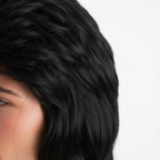 Extreme macro close-up of jet black synthetic mullet wig hair fibres showing texture, sheen and premium material quality