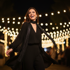 Stylish woman wearing metallic black bohemian fringe scarf at a night festival with bokeh lights