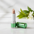W7 Tea Tree Concealer Stick Light/Medium on elegant marble surface with botanical tea tree leaves background