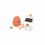 Flat lay of all Scrunchems Sticky Squishy Capybara contents including capybara figure, orange slice stickers, blue sticky balls and packaging with £1 coin for scale