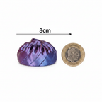 3D Fidget Dumpling 8cm purple violet iridescent squishy toy shown beside £1 coin on white background to demonstrate size