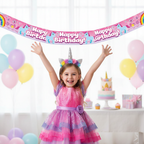 Young girl celebrating at unicorn birthday party with holographic rainbow banner decoration
