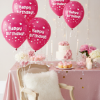 Fuchsia pink heart balloons floating above elegant birthday dessert table with pink themed party decorations