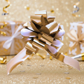 Metallic gold pull bow 31mm fully bloomed on white background, luxury gift wrapping accessory