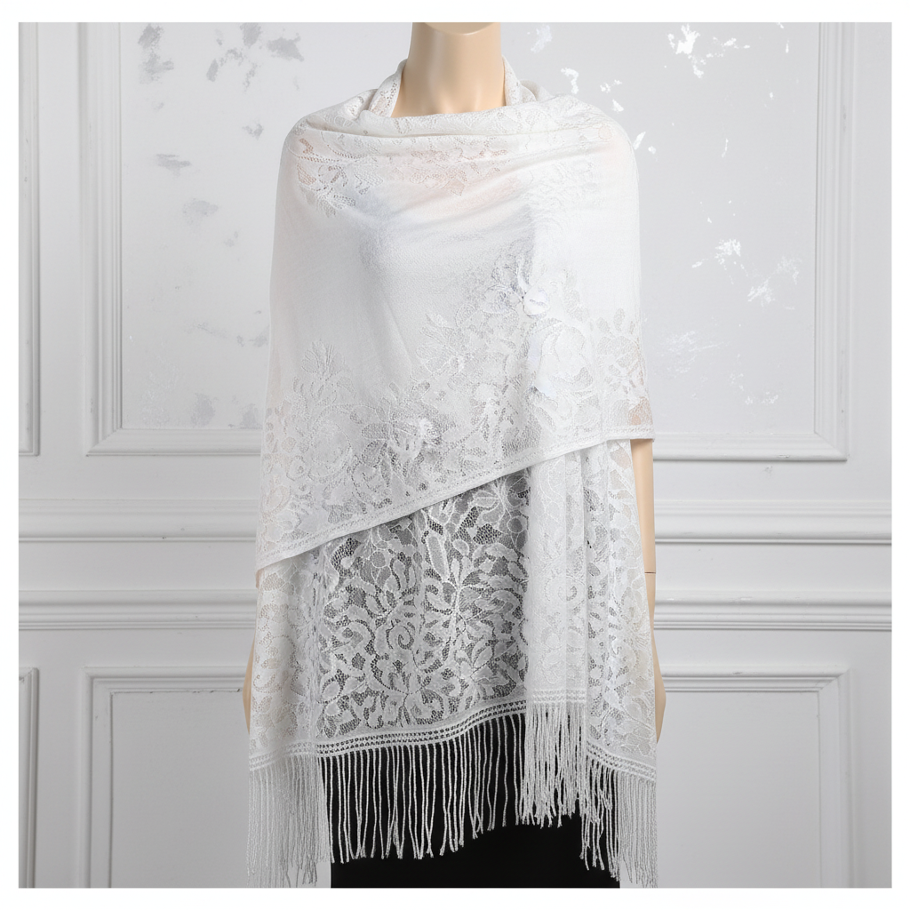 White lace pashmina shawl draped on silver background showing floral lace detail and tassel fringe
