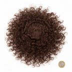 Long curly brown costume wig flat lay beside £1 coin on white background to show scale