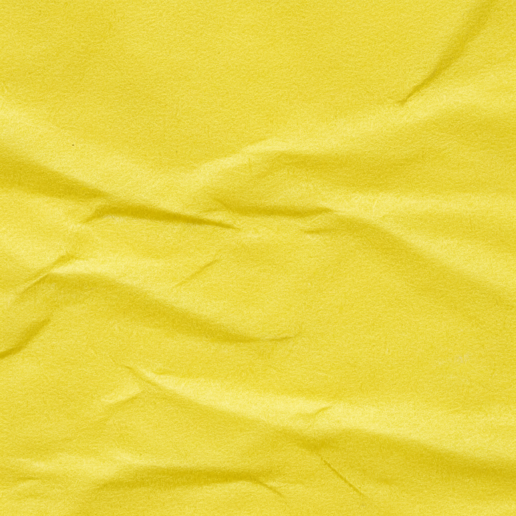 Extreme macro close-up of yellow tissue paper texture showing soft fibrous quality and translucency