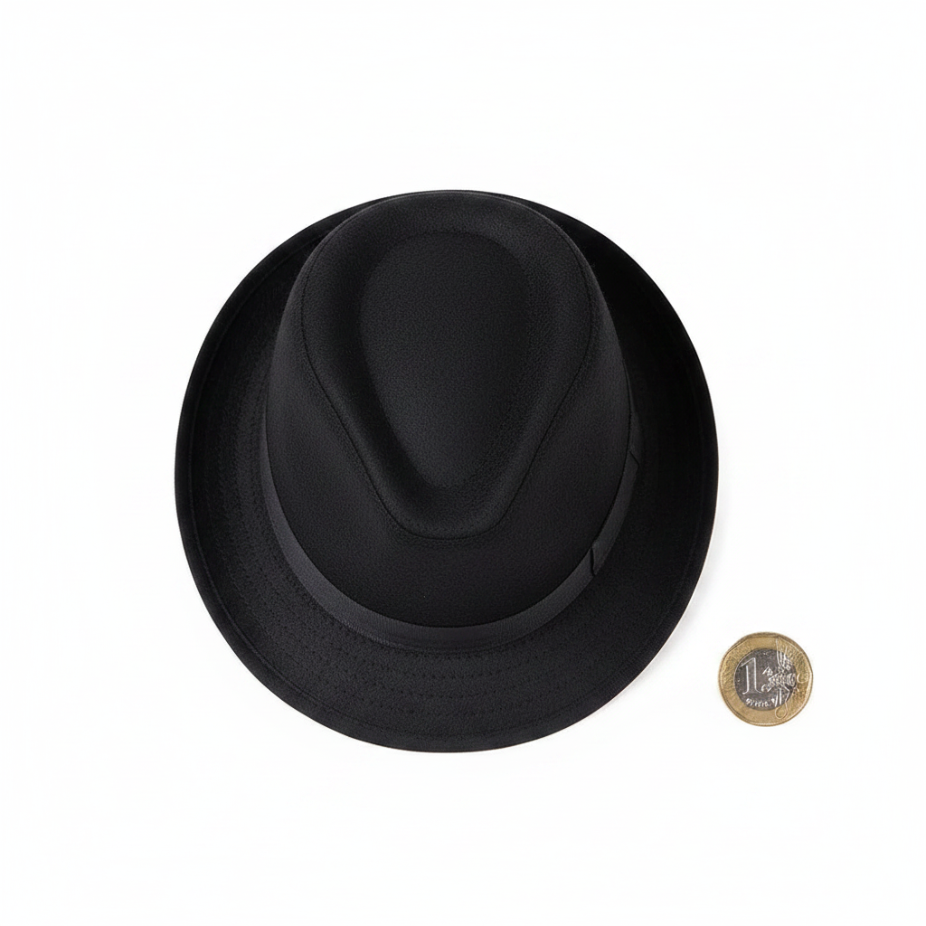 Adults black trilby hat flat lay on white background beside a £1 coin to show scale and size