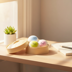 Kawaii squishy bao bun dumplings in bamboo steamer on a wooden shelf beside a small succulent plant and notebook in natural window light