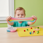 Happy child stretching and playing with colorful Magical Putty for sensory development