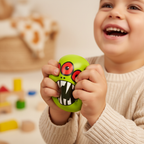 Child laughing and squeezing a lime green monster squishy PU ball with creamy bokeh background