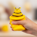 Child's hand squeezing the Squishy Pop Up Beehive yellow foam fidget toy with bee character popping up