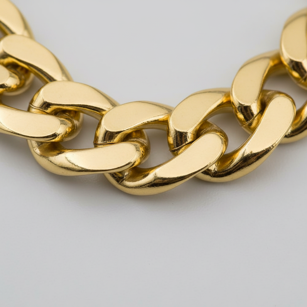 Extreme macro close-up of chunky gold chain necklace links showing high-shine metallic finish and craftsmanship