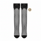 Black fishnet thigh high stockings with satin bow flat lay on white background with £1 coin for scale