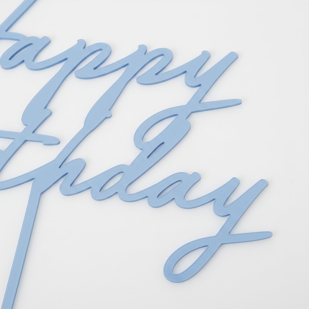 Close-up detail of the misty powder blue acrylic Happy Birthday cake topper showing the laser-cut cursive letterform and smooth flat acrylic surface