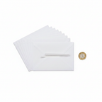 C6 white peel and seal envelopes fanned out beside a £1 coin to show 114x162mm size, flat lay on white background