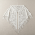 White women's lace triangular shawl scarf displayed on a clean neutral surface showing delicate lace texture and triangular shape