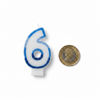 Blue number 6 birthday candle placed beside a £1 coin on white background to show scale and size