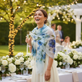 Stylish woman at a summer garden party wearing a blue floral chiffon scarf as a wrap, celebrating with champagne