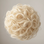 Extreme macro close-up of 613 Daisy platinum blonde curly hair bun showing individual curl texture and premium synthetic fibre quality