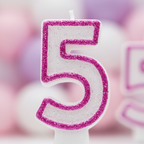 Extreme macro close-up of pink glitter number 5 birthday candle showing hot magenta glitter border texture and pearl wax surface detail