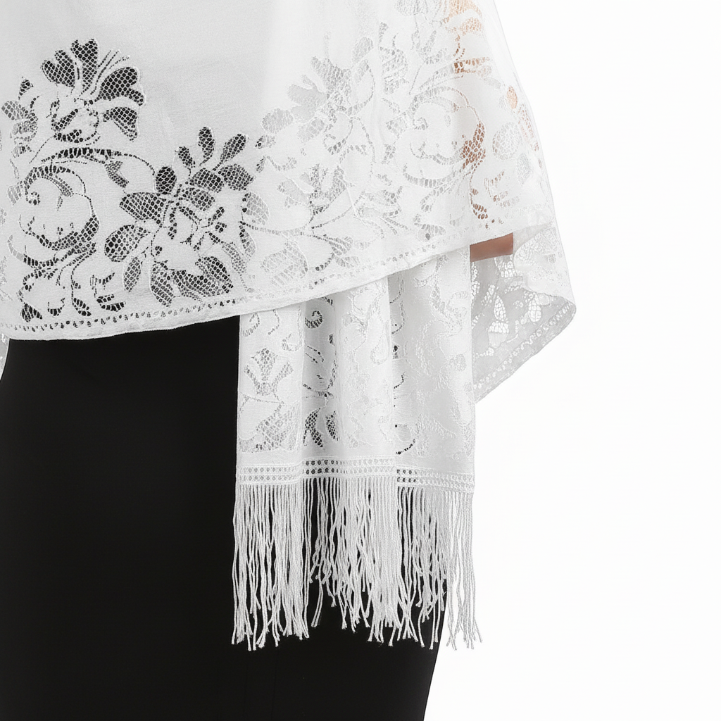 Close-up detail of pure white lace floral pattern and tassel fringe on evening pashmina shawl