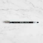 Technic Black Eyeliner Pencil with smudger and sharpener on white marble surface - professional product photography