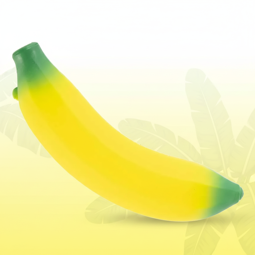 Squishy stretchy banana toy in vivid yellow with green tips on tropical background