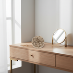 Cool ash blonde curly messy hair bun shade 112 Ash Moon on a dressing table vanity with natural window light, interior magazine styling