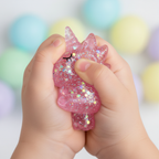 Close-up of child's hands squeezing a glittery gel unicorn toy showing sparkle sugar bead texture inside