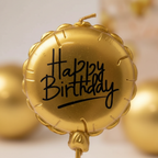 Extreme close-up of gold metallic balloon candle showing Happy Birthday script and sheen