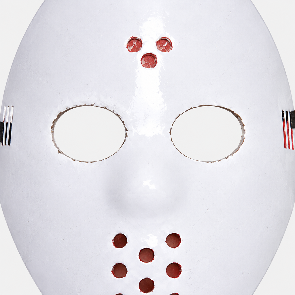 Close-up of white hockey mask showing oval eye openings and small circular ventilation holes