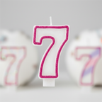 Extreme macro close-up of plain white number 7 birthday candle showing hot pink glitter border detail and pearlescent texture