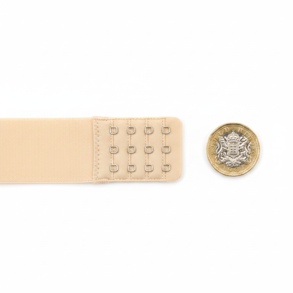 Adorn nude bra extension strap flat lay beside £1 coin on white background showing 3.8cm size scale