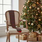 Red and green striped tights draped over vintage wooden chair beside Christmas tree with fairy lights, natural window light
