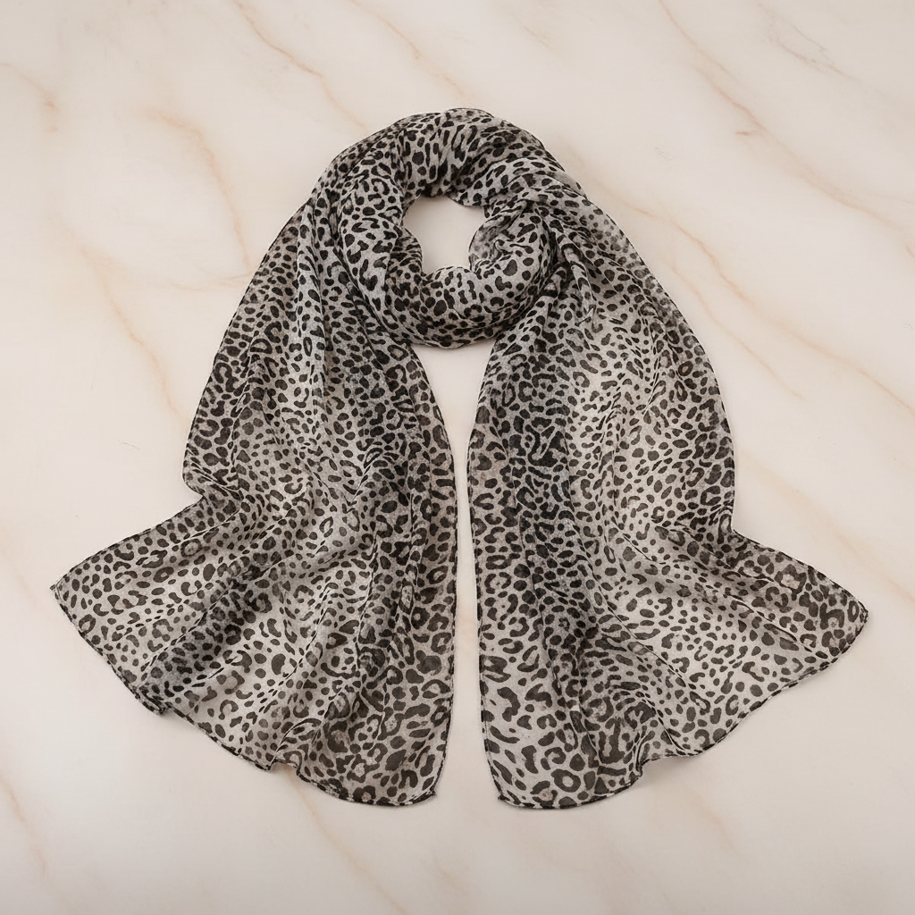 Womens long chiffon animal print scarf in black and beige elegantly draped on a neutral background – studio product shot