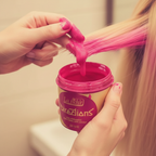 Hands applying La Riche Directions Flamingo Pink hair dye from the gold tub, candid application moment