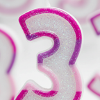 Extreme macro close-up of pink glitter number 3 birthday candle showing iridescent glitter wax texture and fuchsia border detail