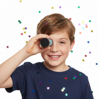 Child holding joke black eye viewer novelty prank toy with cheeky grin