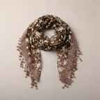 Womens bohemian lace shawl in coffee brown draped on warm neutral background showing intricate lace detail