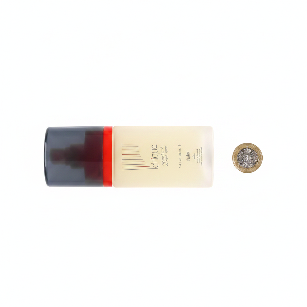 Taylor of London Chique 100ml cologne spray bottle beside a £1 coin on white background showing product scale, professional flat lay photography