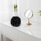 Jet black curly messy hair bun on a dressing table vanity with natural window light, interior magazine styling