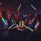 Adults wearing assorted neon glow sticks on lanyards at a New Year's Eve celebration - Why Not Shop