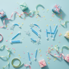 Flat lay of blue party candles 24 pack with holders arranged on a pastel party table with confetti and gifts